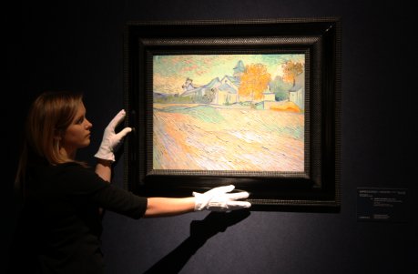Una treballadora de Christie's supervisa el quadre 'Vue de l'asile et de la Chapelle de Saint-Rémy' (1889), de Vincent Van Gogh FOTO: Pous, Laura.